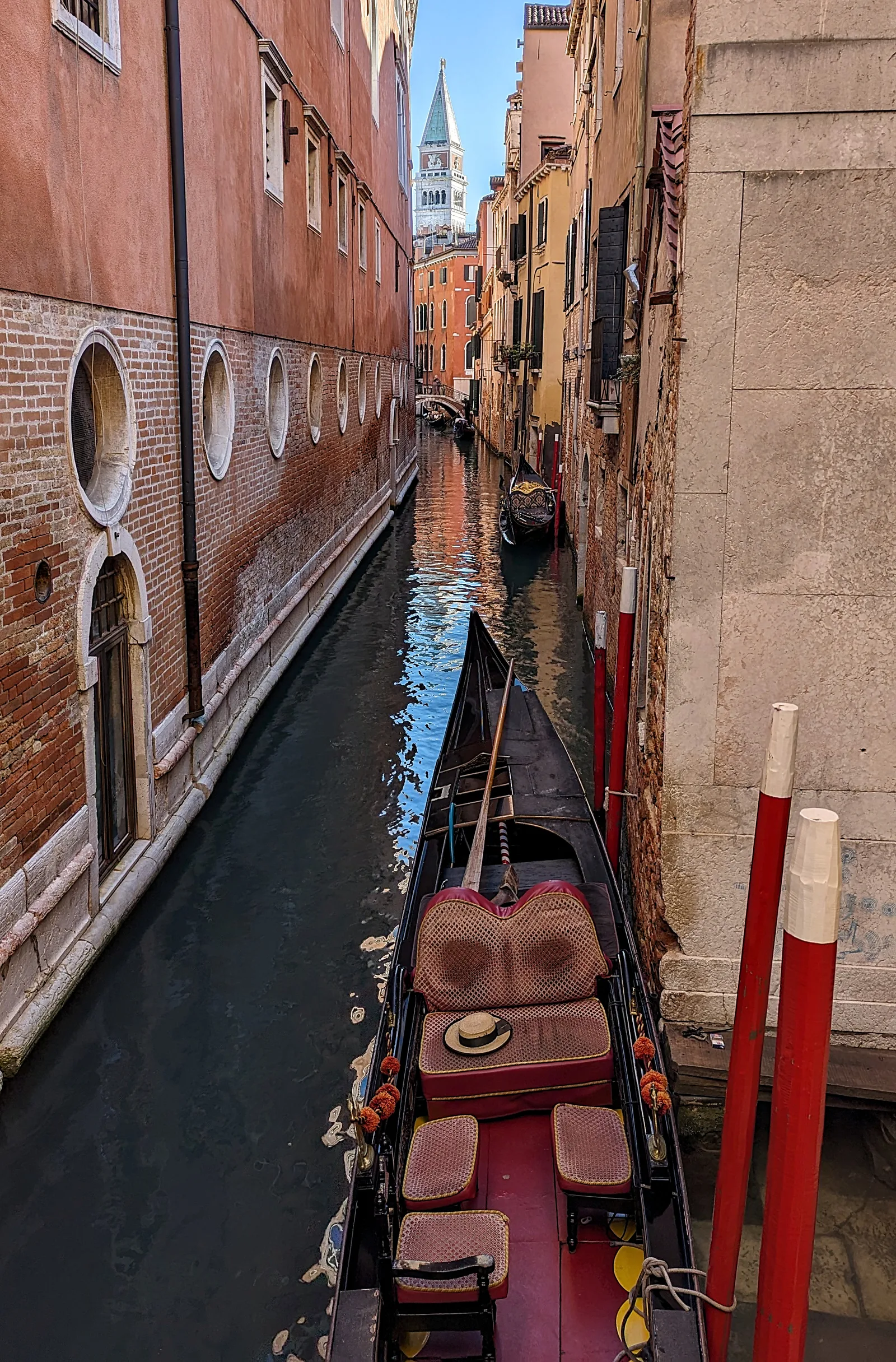 Un'invitante gondola su uno stretto canale con il Campanile di San Marco sullo sfondo