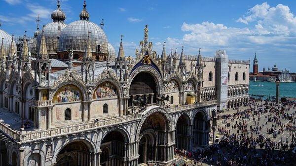 Basilica di San Marco : The western facade, with the adjacent Palazzo Ducale and the lagoon in the background, as seen from Torre dell'Orologio