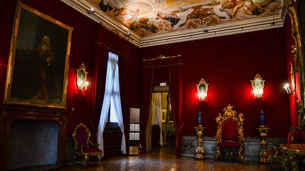 Ca' Rezzonico : The throne room is draped in luxurious red velvet and it derives its name from the ornate gilded wooden throne adorned with cherubs, sea-nymphs, and sea-horses