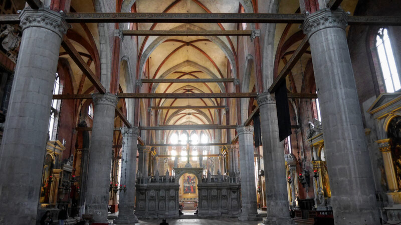 Basilica dei Frari : La navata imponente si apre in modo spettacolare, con l'altare maggiore visibile attraverso l’iconostasi finemente intagliata.