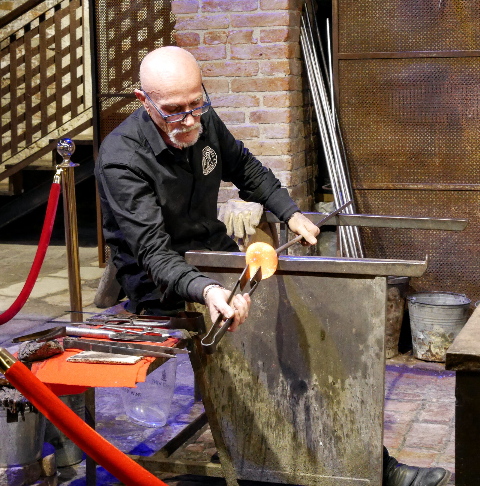 Glass Cathedral : Portions of the still malleable glass are shaped and pulled on a flat metal slab known as a marver