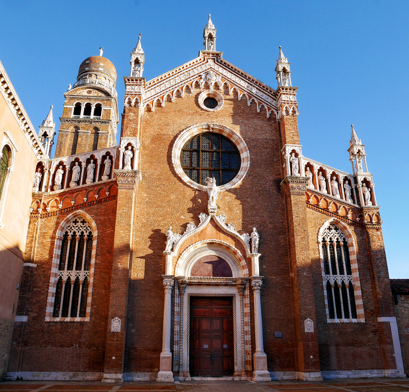 Madonna dell'Orto : Outside, the facade is divided into three sections: the side sections boast quadruple mullioned windows, while the central section houses a large rose window