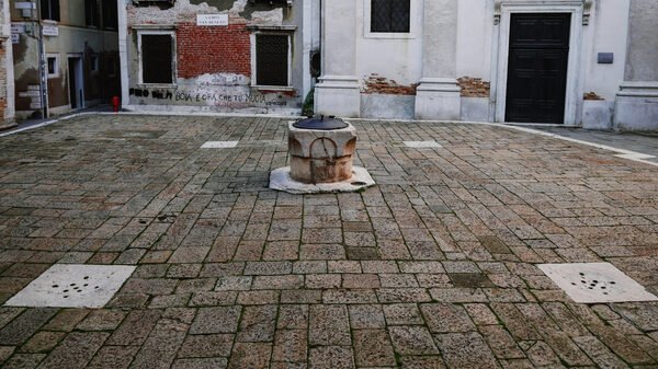 Palazzo Fortuny : Right in front of the entrance you can see a typical Venetian well: a large underground cistern collecting filtered rainwater