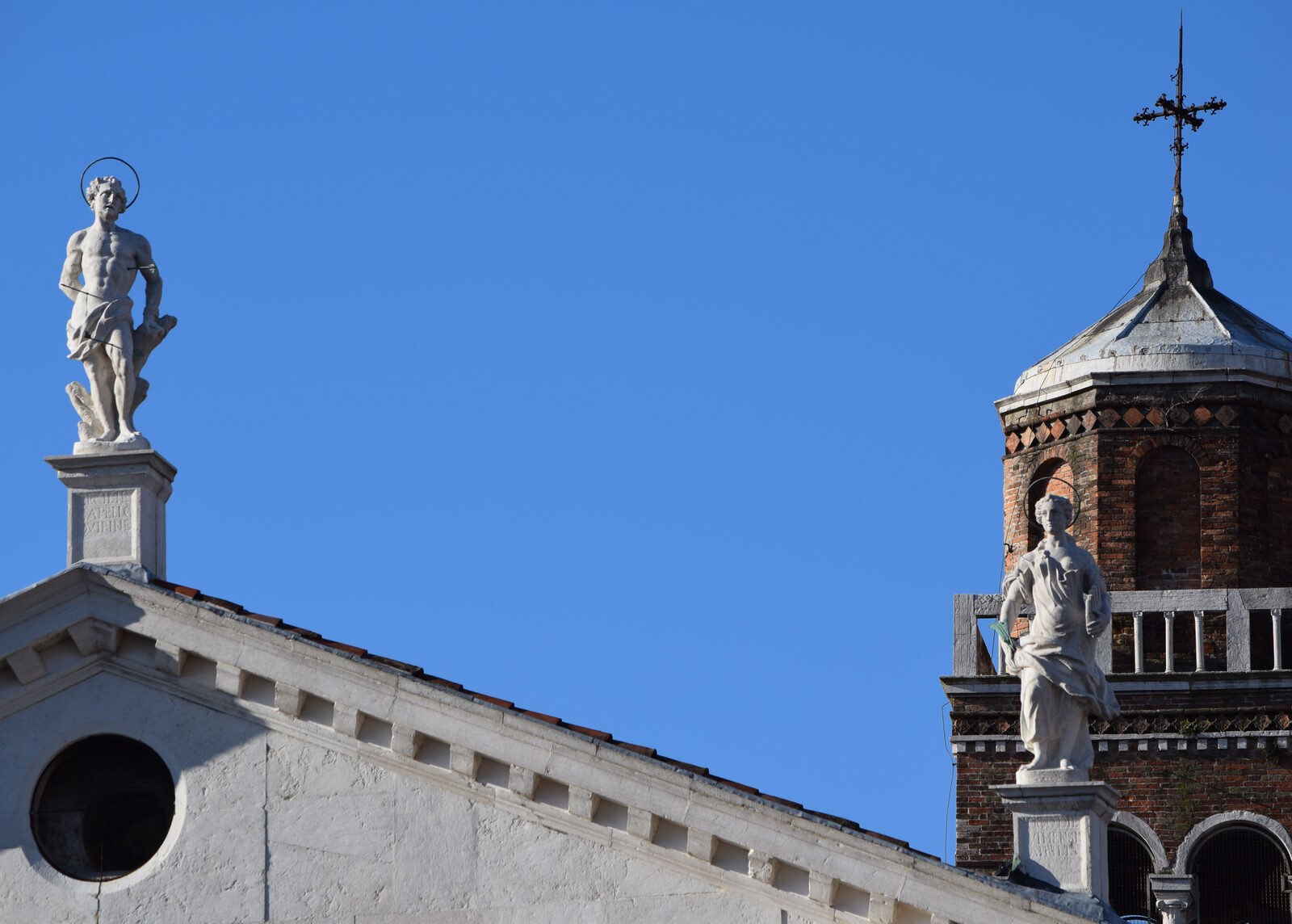 San Sebastiano : The statues of the patron saints with the 53m high freestanding belltower in the background