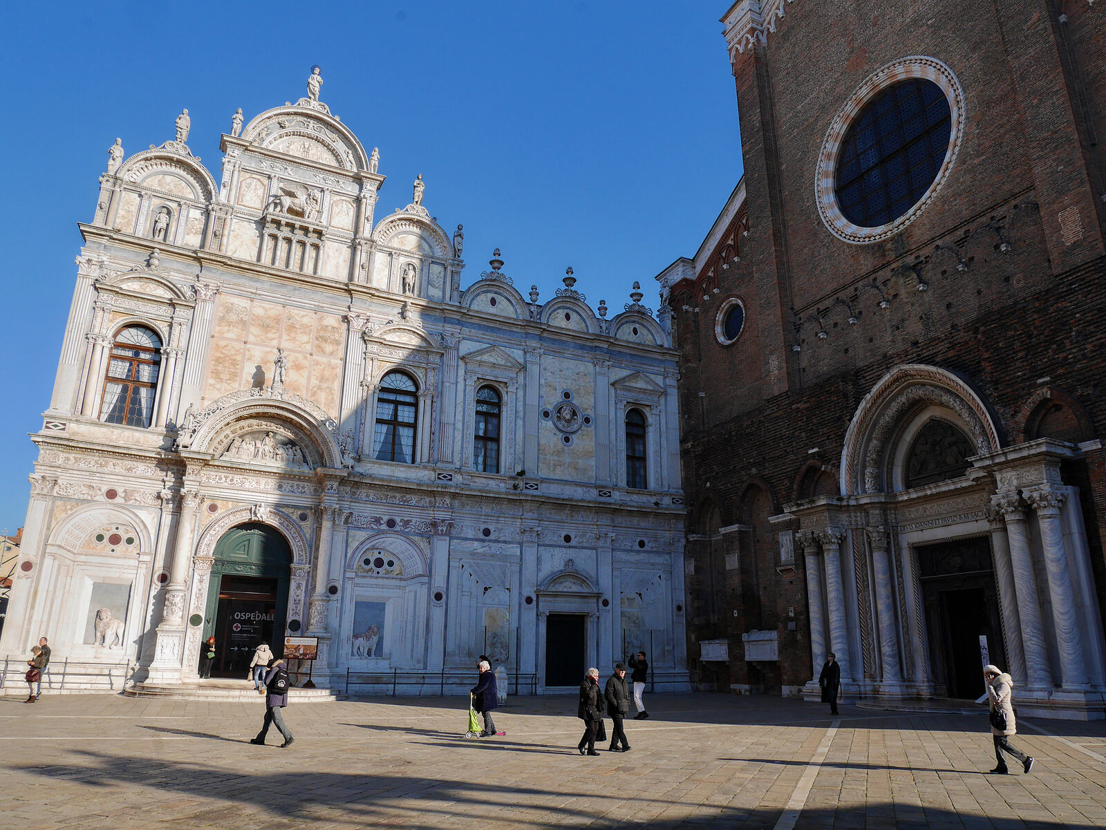 Scuola Grande di San Marco : The lavish facade of the Scuola contrasts with the austere brickwork of the adjacent Santi Giovanni e Paolo