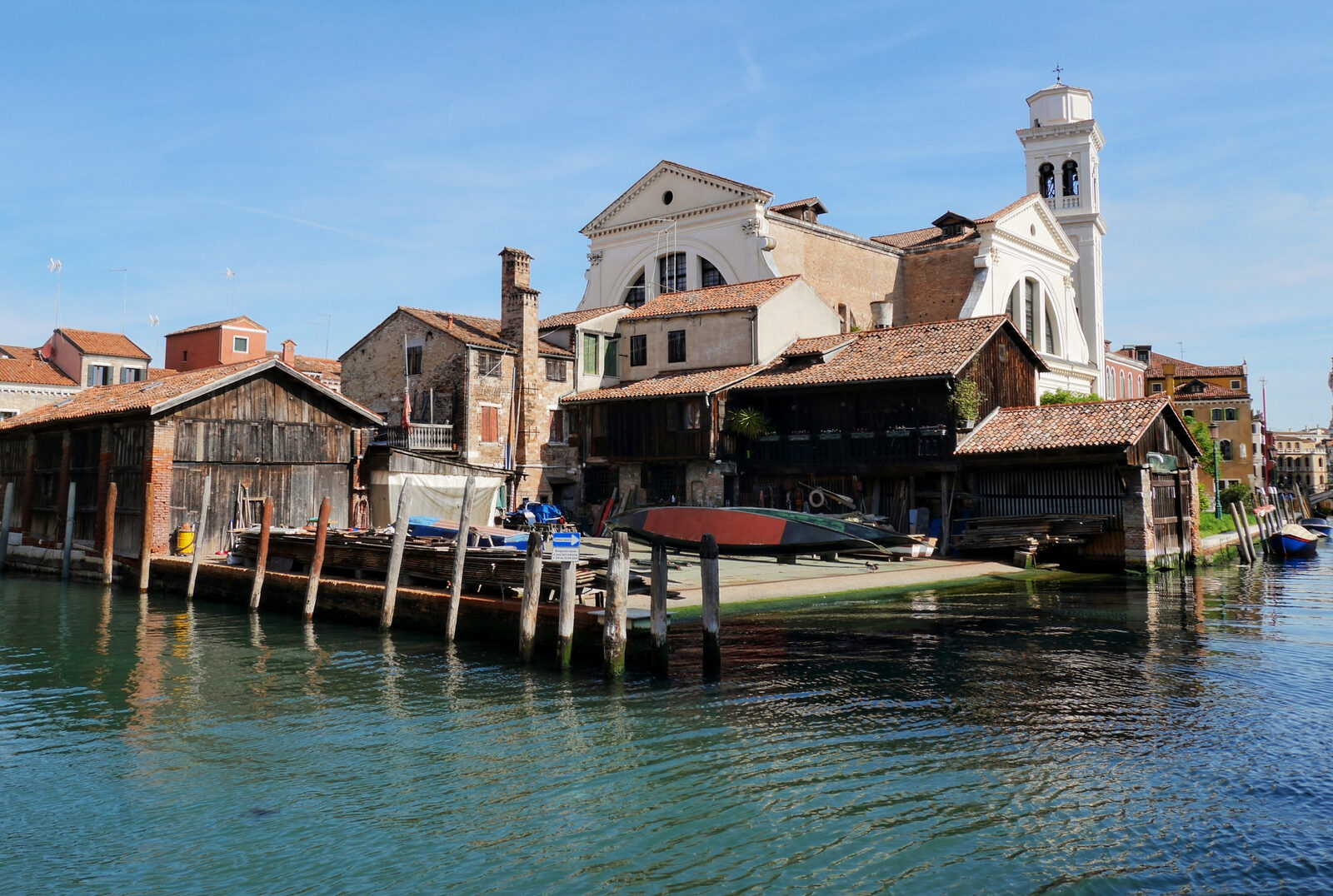 Squero di San Trovaso : Behind the workshop, you can make out the silhouette of the Church of San Trovaso, easily recognized by its rare twin facade design