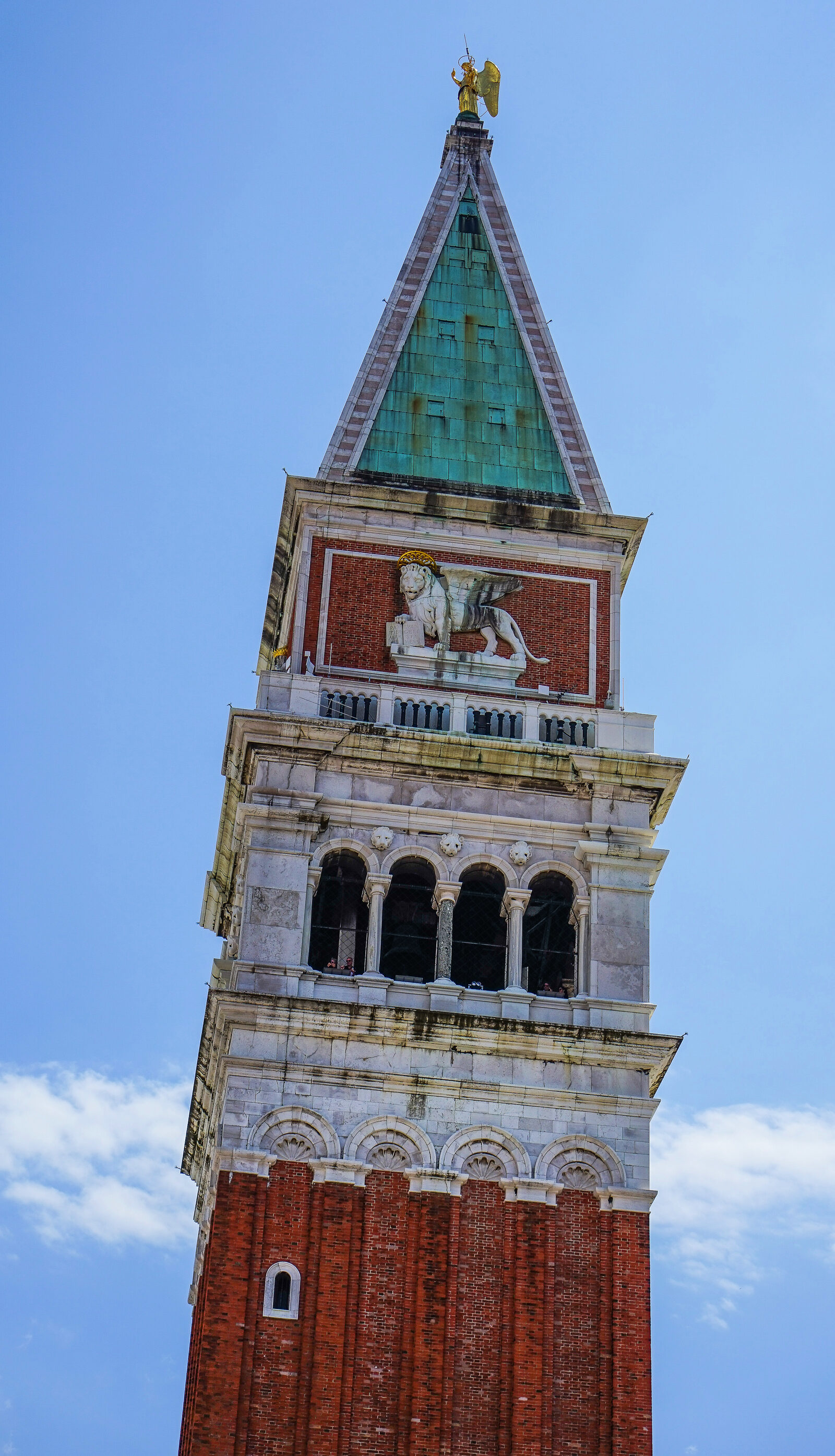San Marco Campanile : The top of the tower features the belfry (where you can climb), the symbol of St. Mark and a pyramidal spire topped by a golden angel