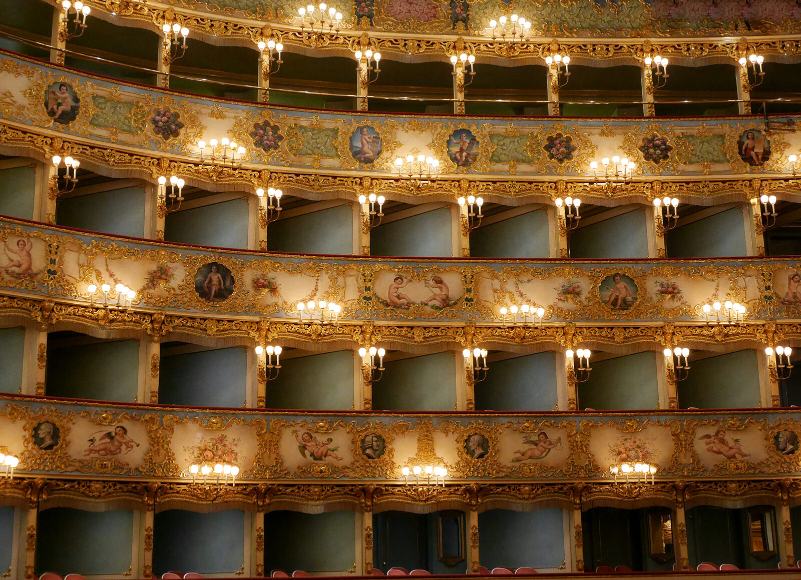 Teatro La Fenice : The paintings outside the boxes feature cherubs with musical instruments or in playful moods, while on the upper levels they hold tablets engraved with the titles and authors of 14 of the most important operas staged in the house
