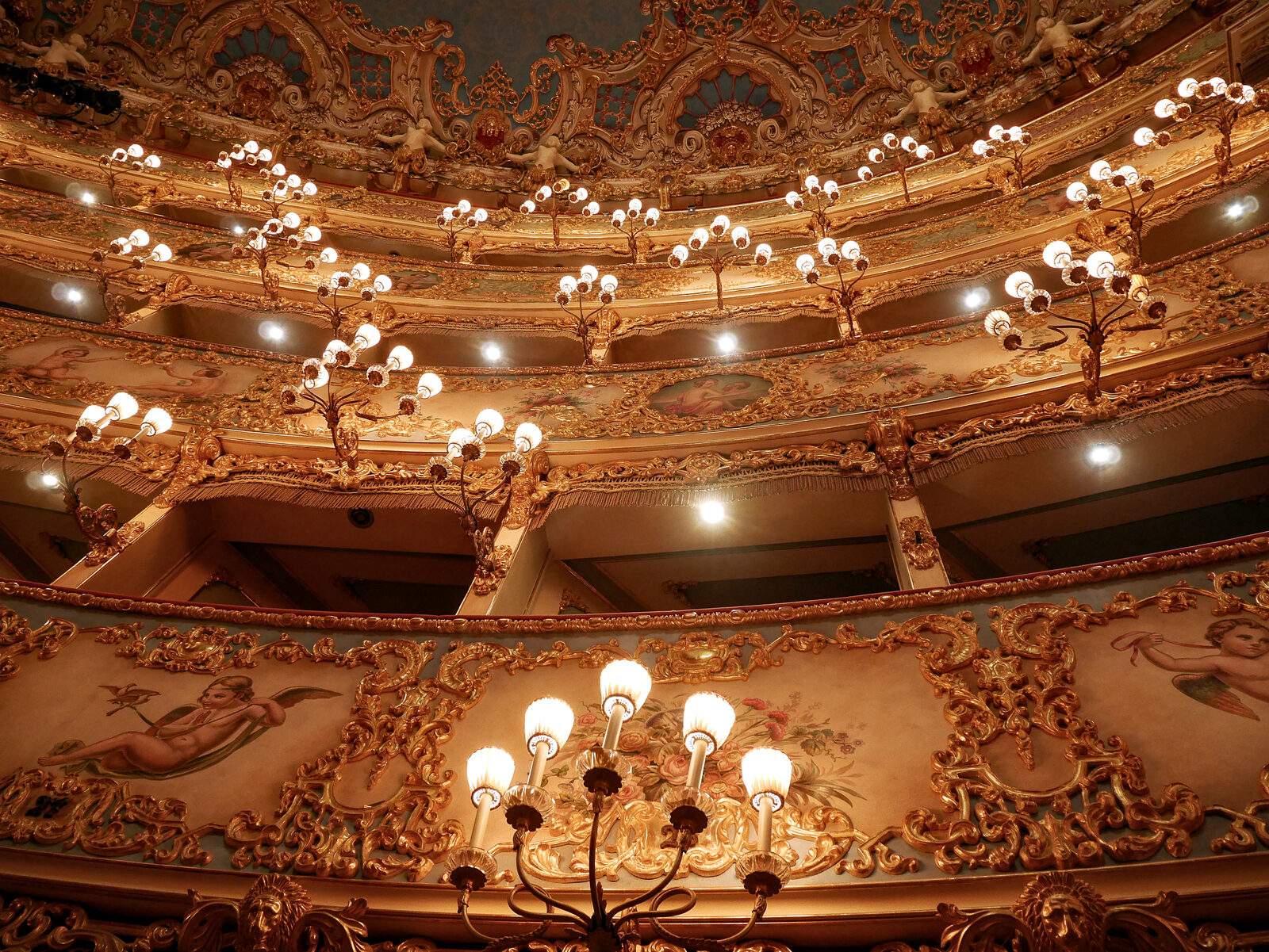 Teatro La Fenice : The ambient light is further enhanced by numerous wall sconces, each with three to five arms, positioned next to the boxes