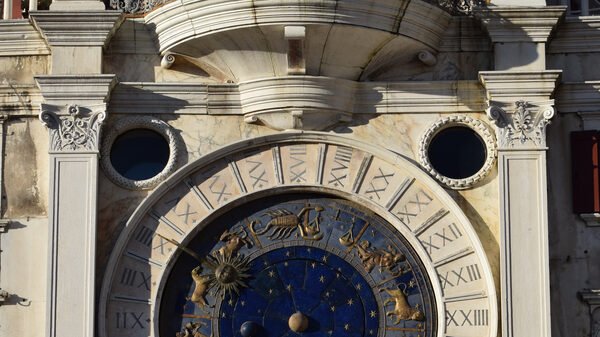 Torre dell'Orologio : The 24-hour dial with zodiac signs, above which sits the Virgin and child statue flanked by two barrels displaying hours and minutes