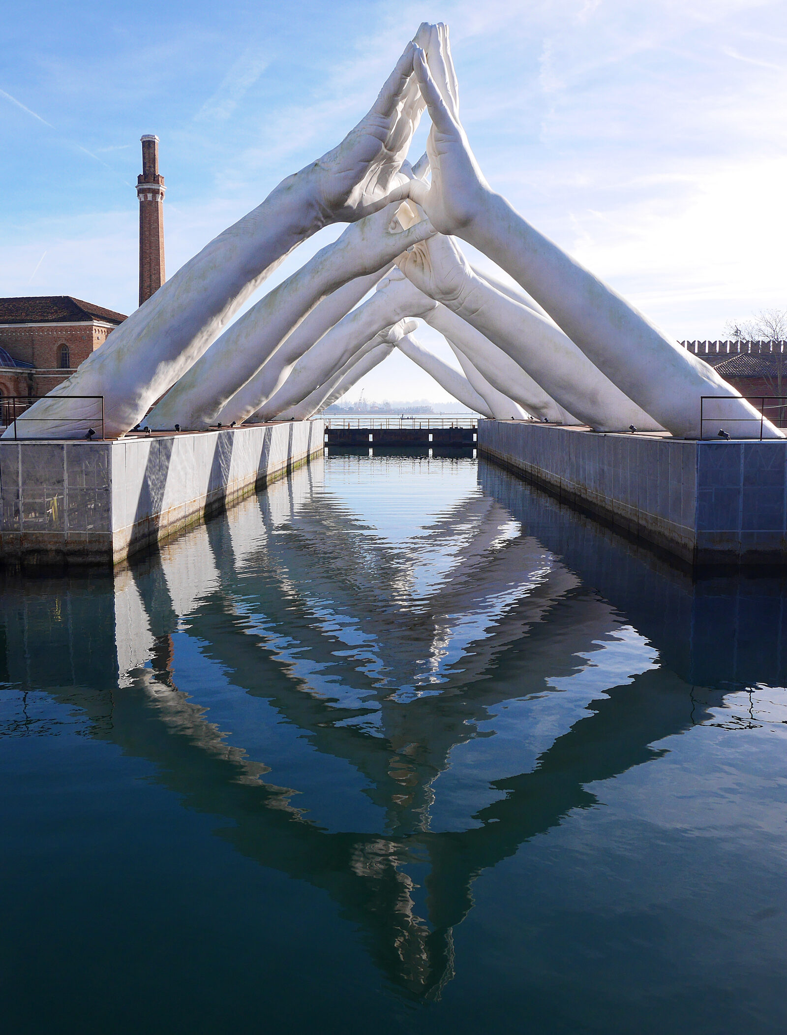 Venetian Arsenal : The Building Bridges sculpture reflected in the water